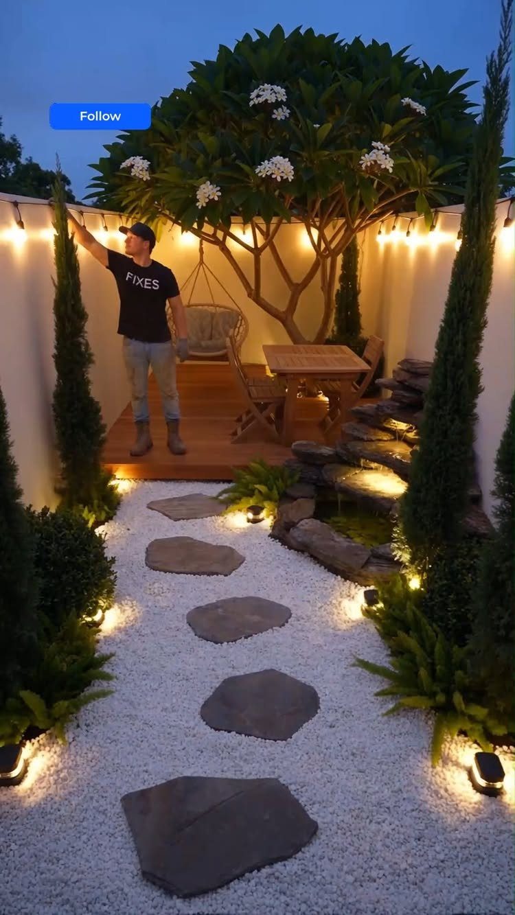 10 Around a Tree Ideas for Better Outdoor Spots 8 A small courtyard garden with a central tree, stone pathway, and warm outdoor lighting.