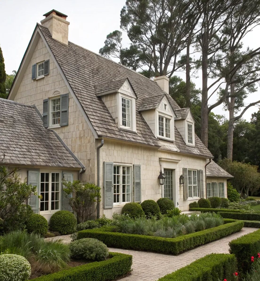 10 Cape Cod Front Yard Landscaping Ideas for Classic Charm 2 Manicured low boxwood hedges create geometric garden beds around a stone cottage with grey shutters.