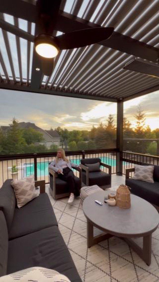17 Deck Covering Ideas for Shade, Style & Rain Shelter 7 A woman relaxing on a modern screened-in deck overlooking a swimming pool at sunset.