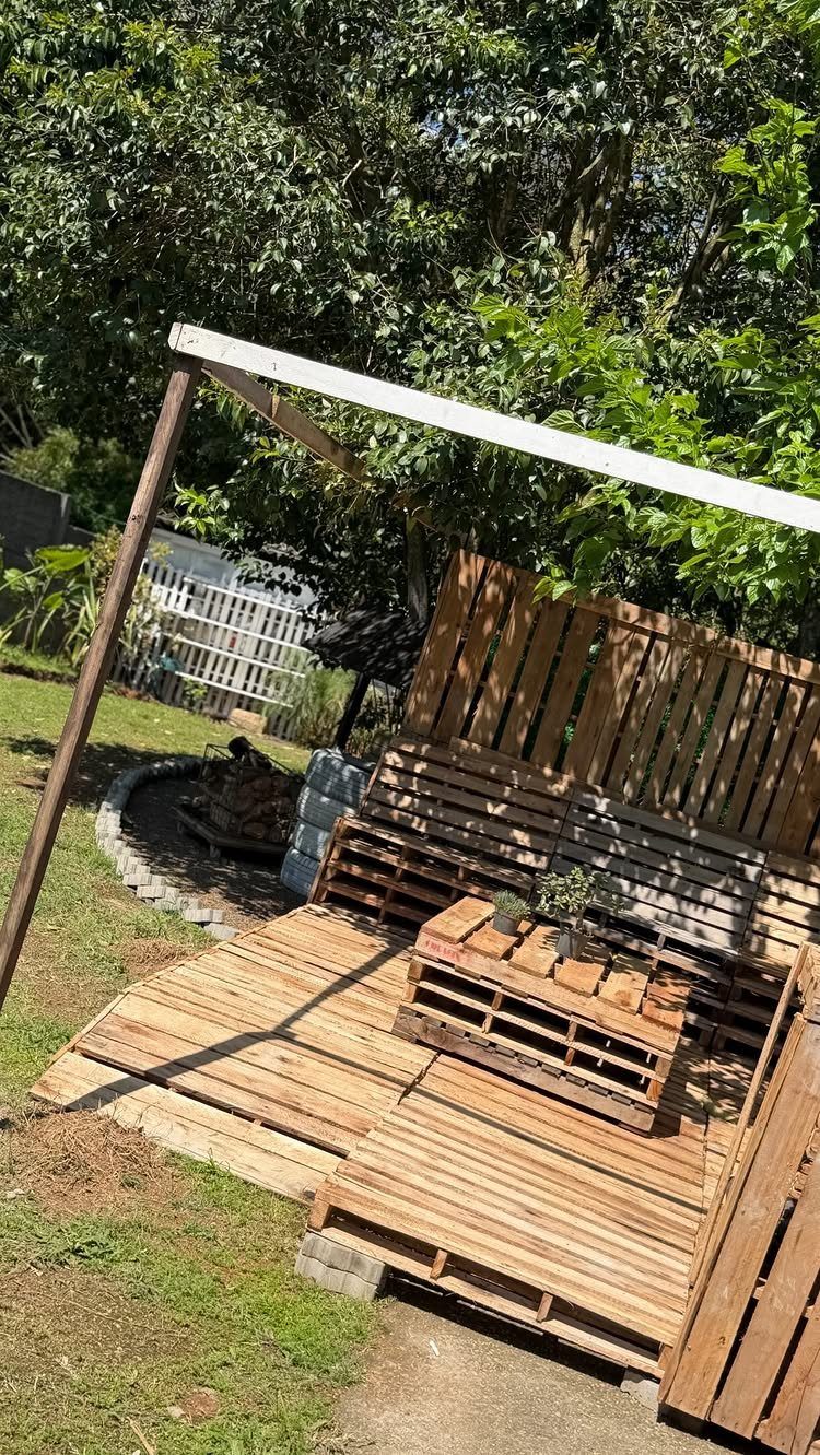 Wooden pallets arranged to create a simple outdoor sitting area on a grassy lawn.