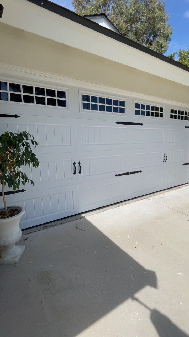 9 Garage Door Makeover Ideas for Instant Curb Appeal 7 White garage door with black decorative magnetic hardware accents and small window panes.