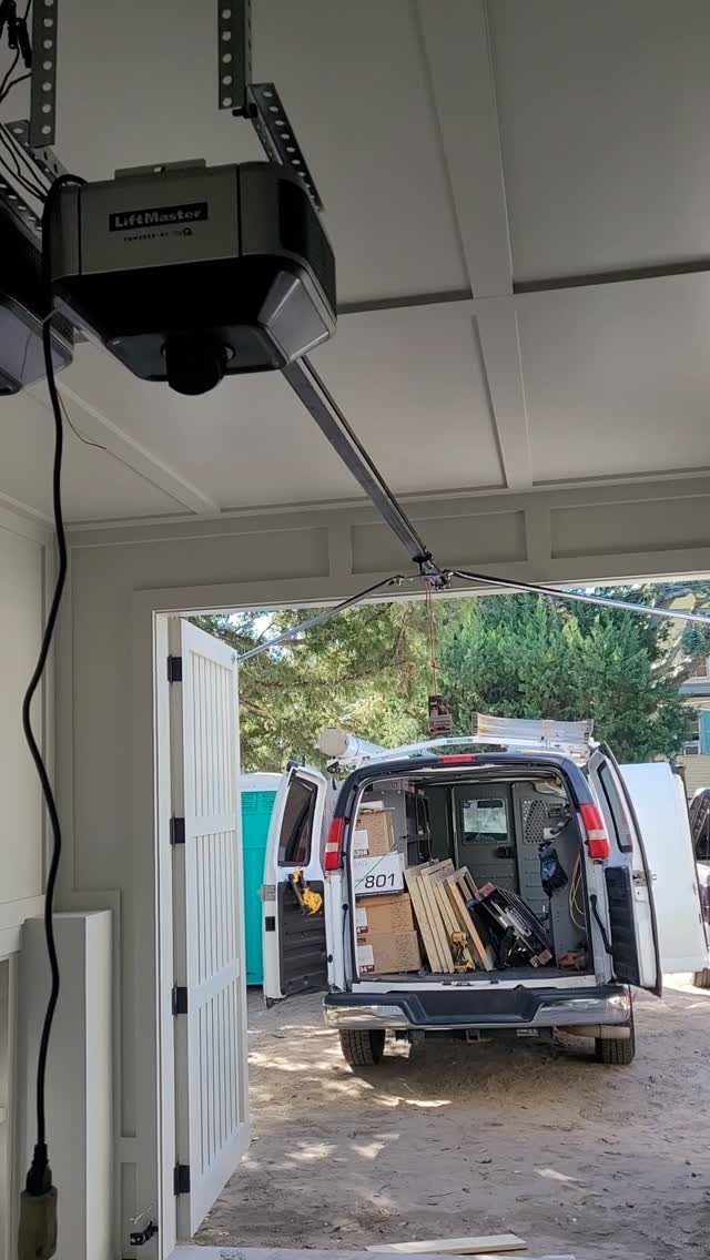 9 Garage Door Makeover Ideas for Instant Curb Appeal 8 A LiftMaster garage door opener mounted to a white ceiling with its motorized arm extended.