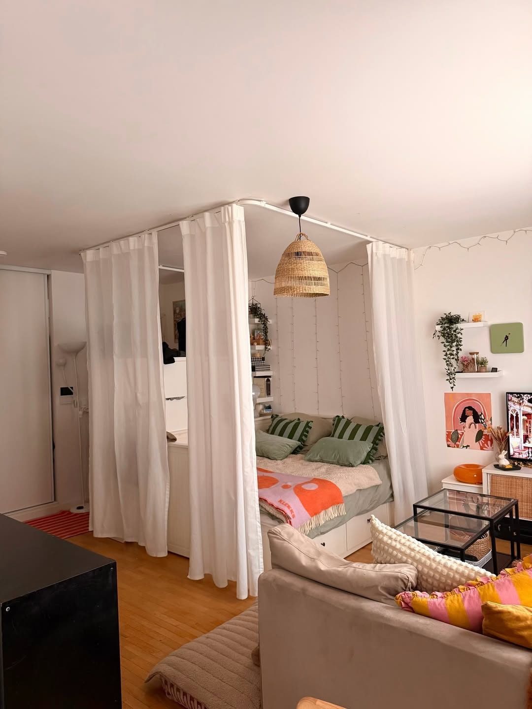Turning a Garage to a Studio Apartment: 9 Layouts That Work 7 A small studio apartment with a curtained-off sleeping nook and woven pendant light.