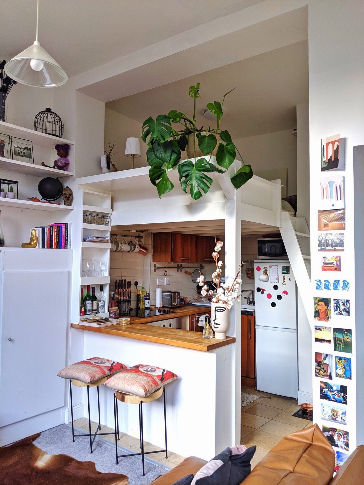 Turning a Garage to a Studio Apartment: 9 Layouts That Work 6 Small white studio apartment with a kitchen, breakfast bar, and a lofted sleeping area.