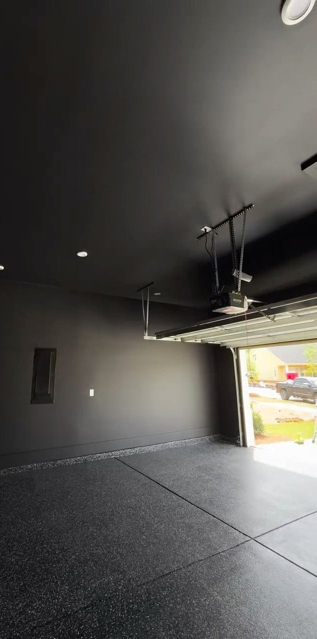 9 Garage Paint Colors for Doors, Floors, Walls and Ceiling 8 A modern garage featuring matte black walls and ceiling with a dark grey speckled epoxy floor.