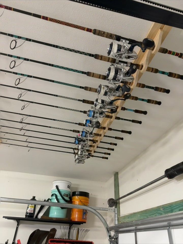 11 Garage Storage Inspiration and Ceiling Systems That Actually Fit 6 Fishing rods with reels mounted horizontally to a wooden beam on a garage ceiling.