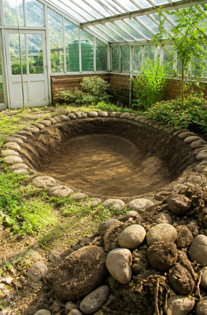 Greenhouse with Fish Pond: How to Build an Aquaponics Setup 1 A hand-dug pond showing smooth edges and clear water.