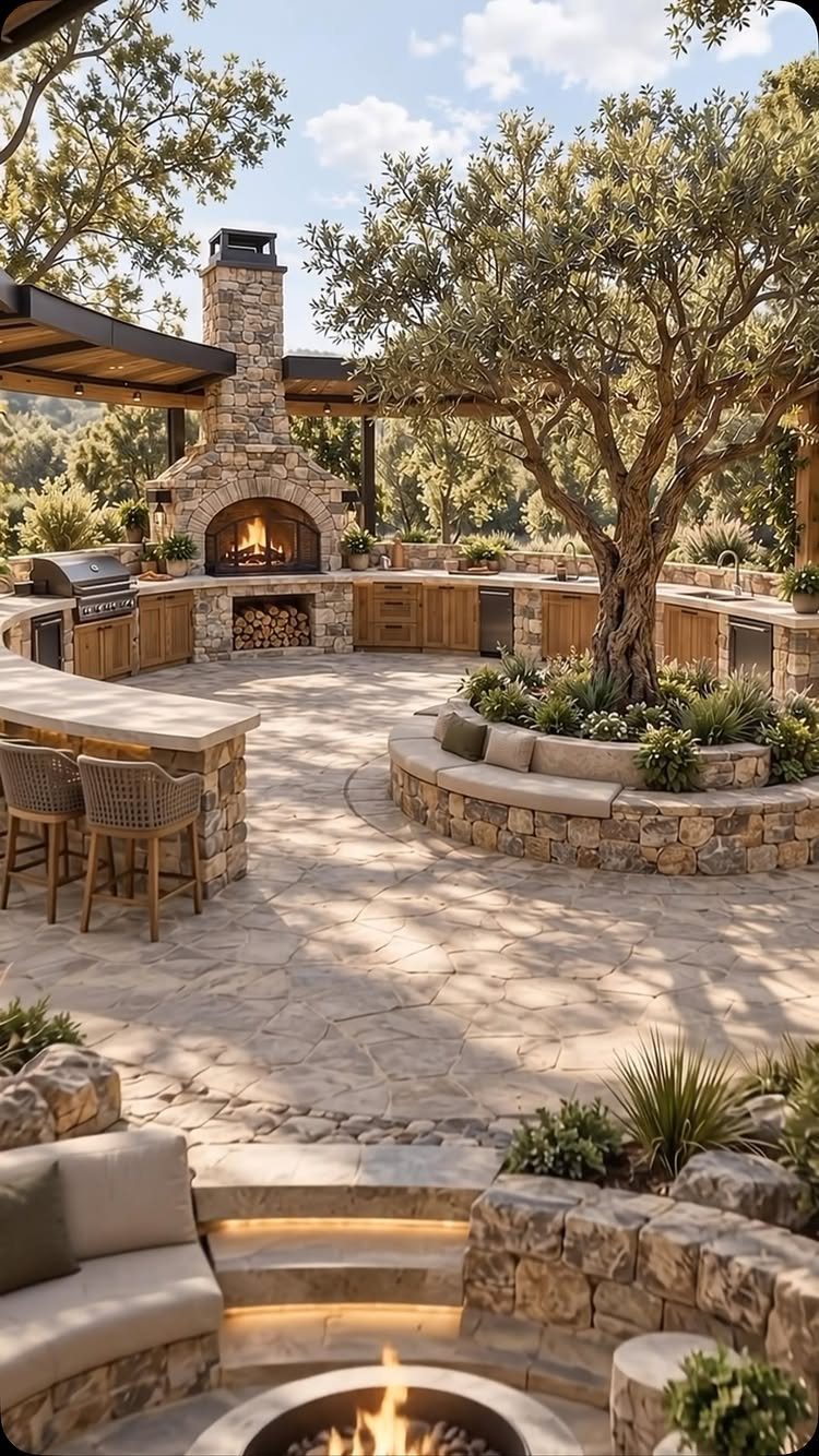 18 Large Yard Ideas for Patios, Pools, Outdoor Kitchens & More 11 A large stone patio featuring an outdoor kitchen, fireplace, and sunken fire pit area around a tree.