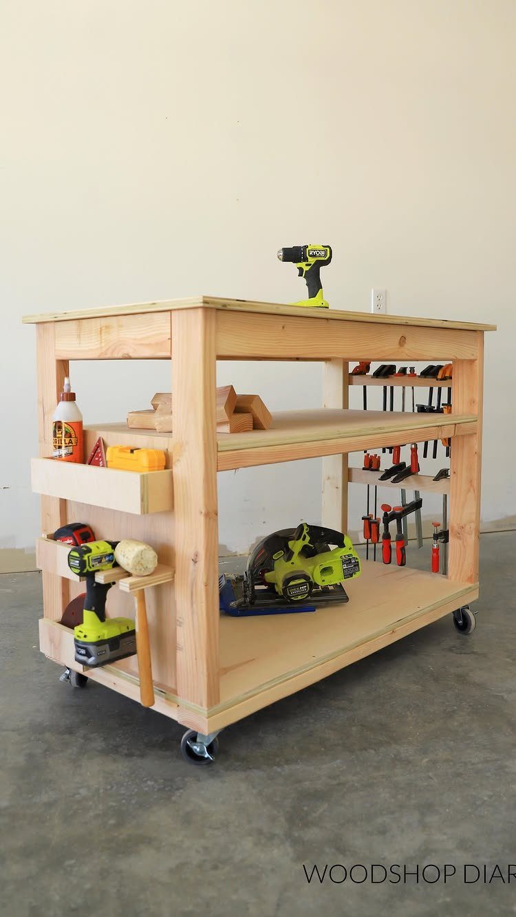 12 One Car Garage Workshop Layout Ideas That Save Space 9 A wooden mobile workbench with multiple shelves holding various woodworking tools on a concrete floor.