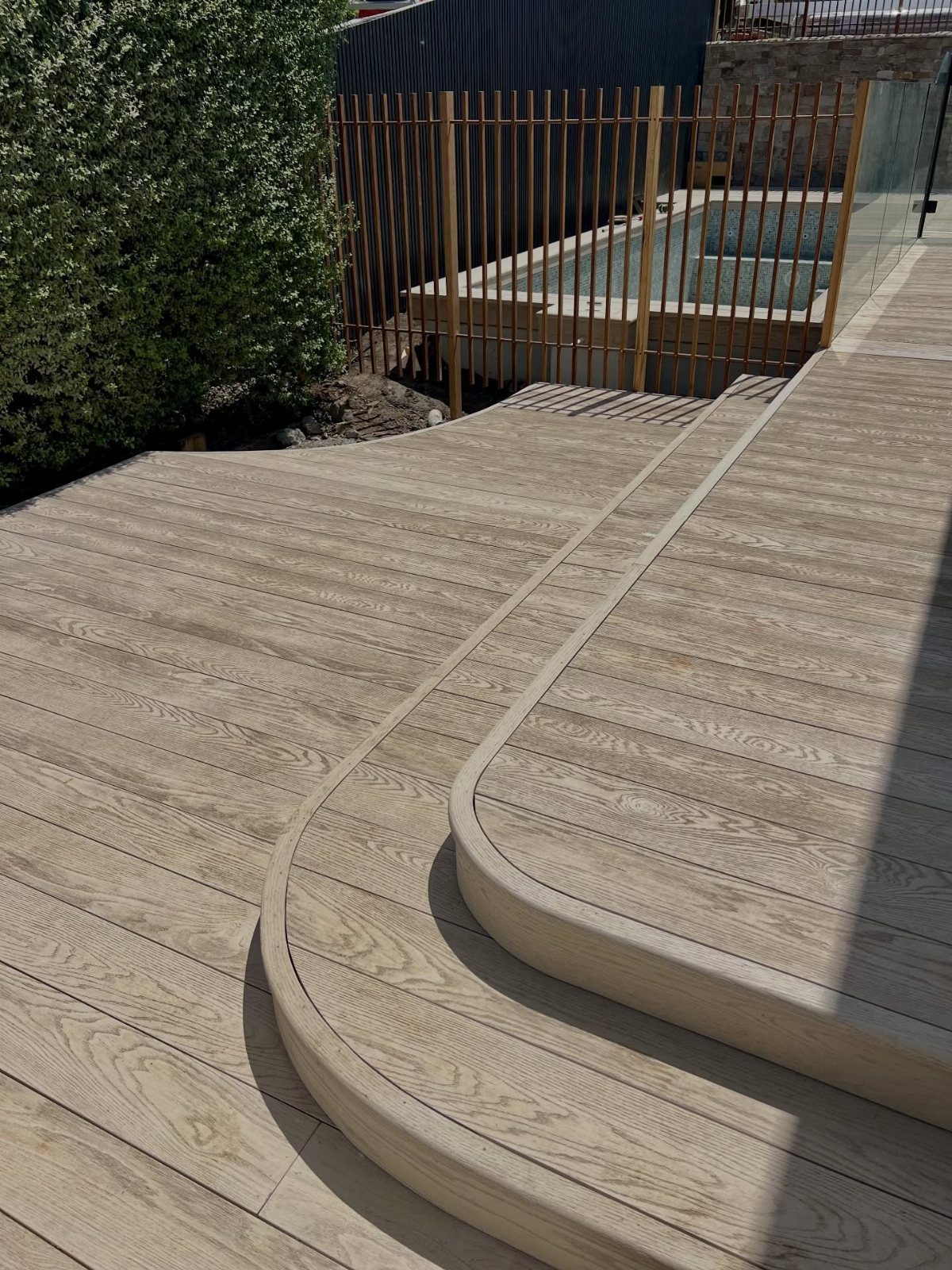 12 Trex Deck Floor Designs for Picture Frames to Herringbone 4 Curved composite decking steps with light wood grain texture in an outdoor garden setting.