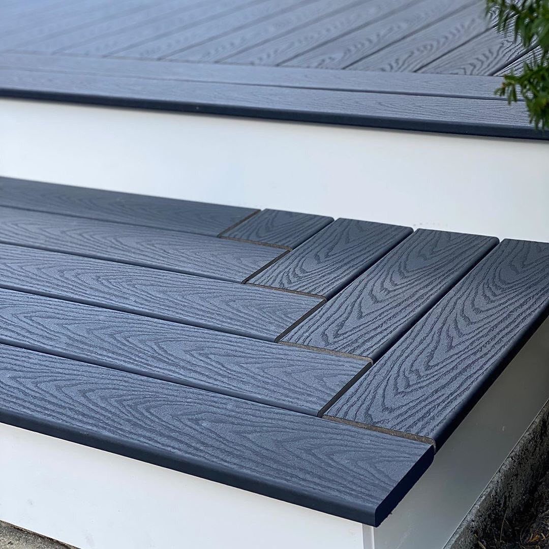 12 Trex Deck Floor Designs for Picture Frames to Herringbone 8 Dark blue composite deck boards arranged in a herringbone pattern on a step.