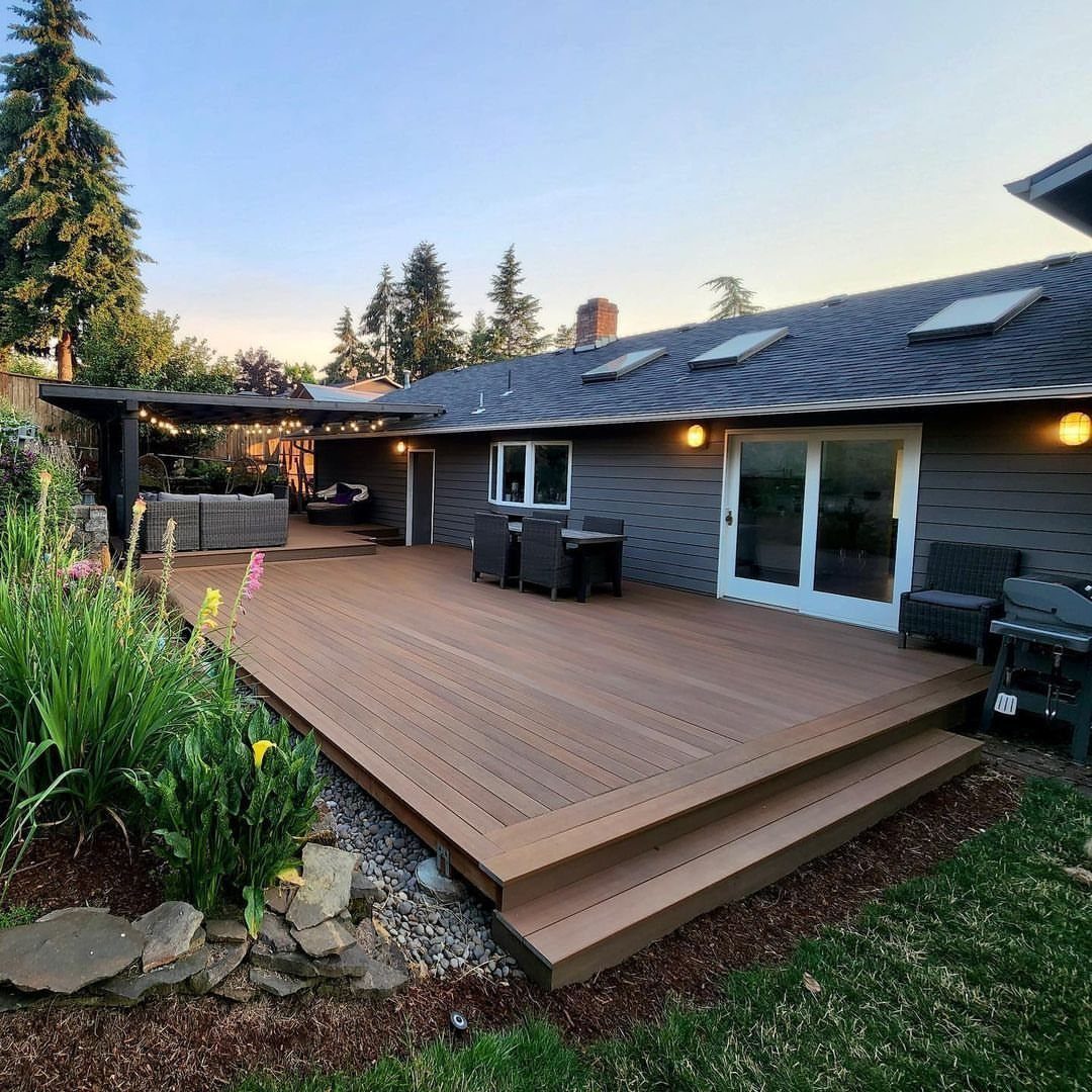 12 Trex Deck Floor Designs for Picture Frames to Herringbone 10 A large brown composite wood deck with outdoor furniture attached to a grey house.