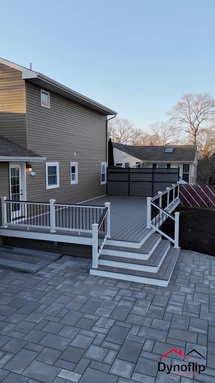 12 Trex Deck Floor Designs for Picture Frames to Herringbone 5 Grey composite deck with white railings and a dark privacy screen attached to a tan house.