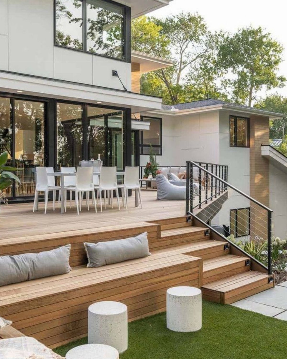 12 Trex Deck Floor Designs for Picture Frames to Herringbone 7 Modern wooden deck featuring tiered built-in seating and white outdoor dining furniture.