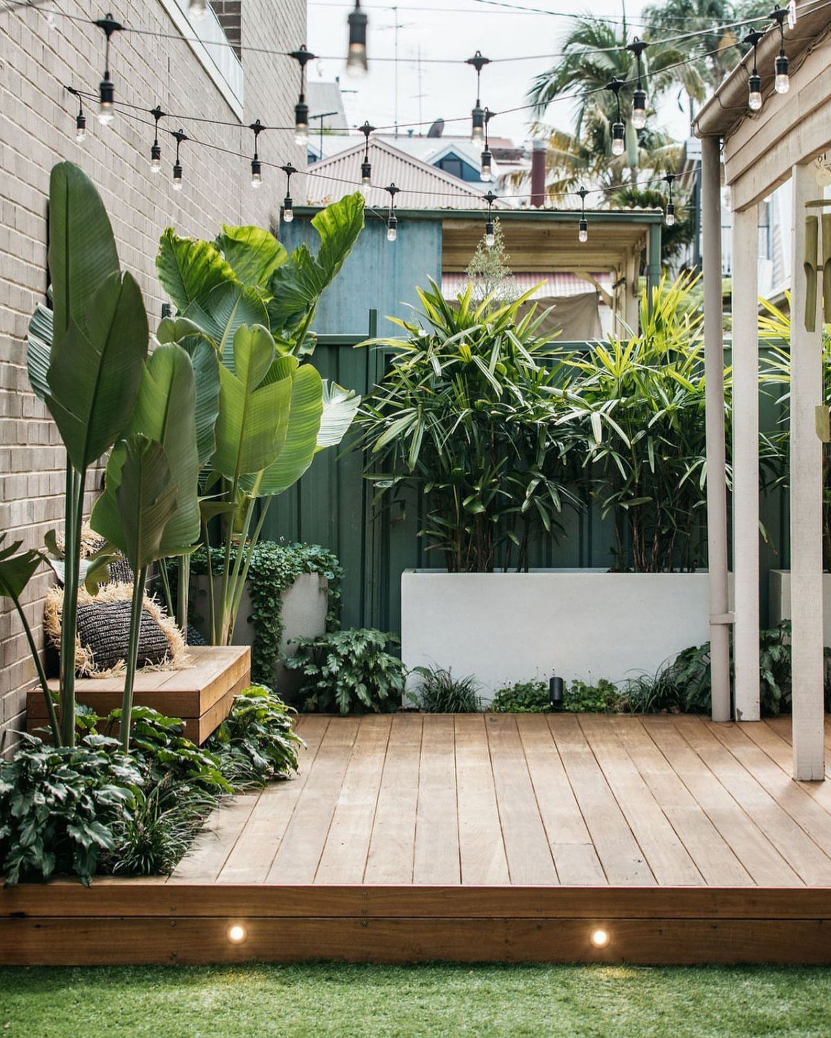 12 Trex Deck Floor Designs for Picture Frames to Herringbone 2 Light brown wooden deck planks laid in a simple parallel pattern surrounded by tropical greenery.