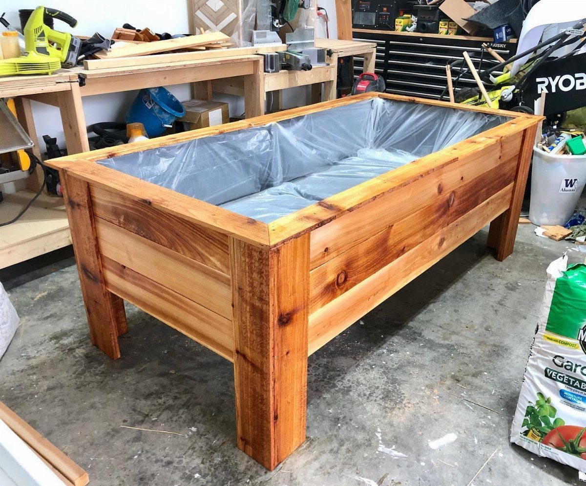 Wood Planter Box: 11 Ideas from Scrap Builds to Built-In Benches 9 A large rectangular wooden planter box with plastic lining sitting on a workshop floor.