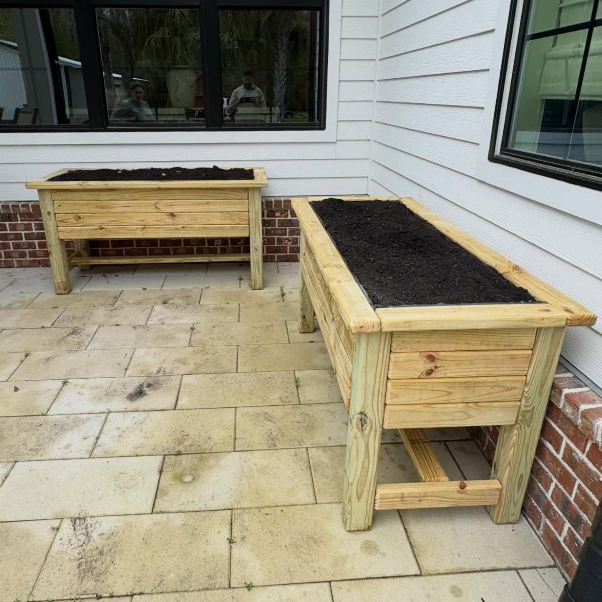 Wood Planter Box: 11 Ideas from Scrap Builds to Built-In Benches 1 Two rectangular wooden planter boxes filled with soil on a stone patio.